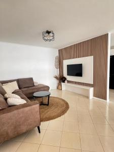 a living room with a couch and a tv at Casa Copacabana in Mindelo +7 photos