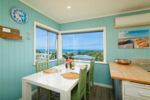 a kitchen with a table with two children sitting at it at Classic Charm, Sea & Mountain Views, Family Fun - KK95170 in Kaikoura