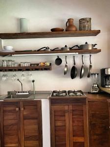 a kitchen with a stove and some pots and pans at Cabañas Uma 1 in San Agustinillo +43 photos