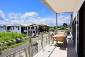 a balcony with a table and chairs and a view of a street at JJY Apartment in Nadi