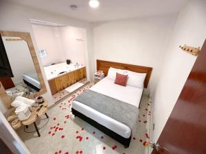 a bedroom with a bed and a bathroom with a tub at Hostal Rose Moor in Jardin