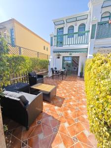 eine Terrasse mit Sofas und einem Tisch vor einem Gebäude in der Unterkunft Paradise Tropical Sun Maspalomas in San Bartolomé de Tirajana + 19 Fotos