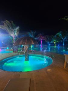 a small pool with an umbrella at night at Alma suite, laguna beach in Tolú