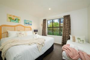 a bedroom with two beds and a window at Classic Charm, Sea & Mountain Views, Family Fun - KK95170 in Kaikoura