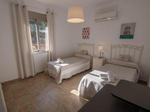 Una pequeña habitación con dos camas y una ventana. en Villa 12 by Villamya, en El Gastor