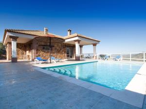 una villa con piscina y sombrilla en Villa 12 by Villamya, en El Gastor