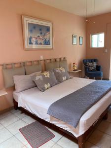 a large bed in a bedroom with a blue chair at Quinta Ángeles in Cuernavaca