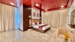 a bedroom with a bed and a couch and a chair at adiMOUNT-Kumaon Eco Resort in Dwārāhāt +88 photos