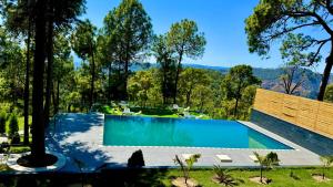 a swimming pool with a view of the mountains at adiMOUNT-Kumaon Eco Resort in Dwārāhāt