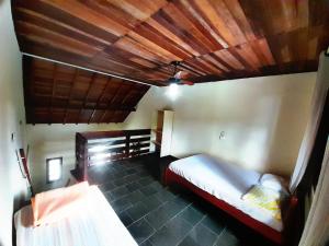 a bedroom with a bed and a wooden ceiling at Pousada Atobá Bertioga in Bertioga