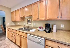 eine Küche mit Holzschränken und einer Spüle in der Unterkunft Charming 1BDR Condo w Spectacular Golf Course View - 5518 in Traverse City