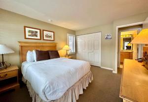 ein Schlafzimmer mit einem großen weißen Bett mit zwei Lampen in der Unterkunft Charming 1BDR Condo w Spectacular Golf Course View - 5518 in Traverse City
