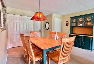 ein Esszimmer mit einem Holztisch und Stühlen in der Unterkunft Charming 1BDR Condo w Spectacular Golf Course View - 5518 in Traverse City