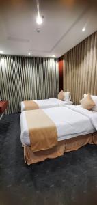 twee grote bedden in een hotelkamer met bij الجوهرة بارك 1 in Riyad