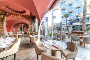 un restaurante con mesas y sillas y un edificio en FIVE Palm Jumeirah 2BR Luxury Penthouse , Full Marina See View with Private Pool, en Dubái