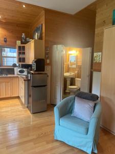 a living room with a blue couch and a kitchen at Acre By the Sea Guest Suite in Sooke