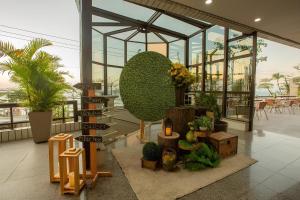 a lobby with plants and signs in a building at Flat Particular em Blue Tree Towers Beira Mar Fortaleza in Fortaleza