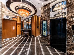 a lobby with a tile floor and a chandelier at APA Hotel Shibuya Dogenzakaue in Tokyo