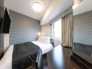 a hotel room with a bed and a large window at APA Hotel Shibuya Dogenzakaue in Tokyo