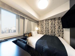 a hotel room with a bed and a window at APA Hotel Shibuya Dogenzakaue in Tokyo