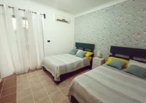a bedroom with two beds in a room at Amplio, cómodo y junto a la playa de Boca Chica in Boca Chica