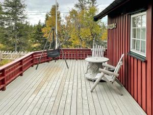 eine Veranda mit einer Schaukel und einem Stuhl auf einer Terrasse in der Unterkunft Family Cabin With Sun And Views At Ljøsheim in Mesnali