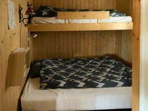 2 Etagenbetten in einem Holzzimmer mit einem Bettlaken in der Unterkunft Family Cabin With Sun And Views At Ljøsheim in Mesnali