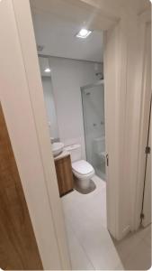 a white bathroom with a toilet and a sink at Apartamento Familiar! in Pelotas