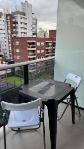 a black table and two white chairs on a balcony at Be one FIT 26 in Montevideo