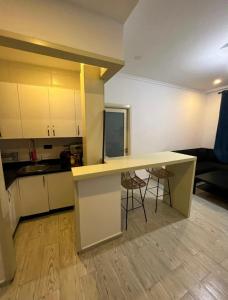 a kitchen with a counter and chairs in a room at Tingis Concept in Tangier +11 photos
