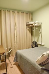 1 dormitorio con cama, silla y cortinas en Apartamento Novo em Londrina, en Londrina 24 fotos más