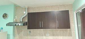 a kitchen with brown cabinets and a sink at Departamento Dulce Adelina I - Zona Céntrica in Río Grande