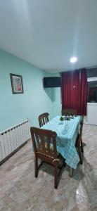 a dining room with a table and chairs and a red curtain at Departamento Dulce Adelina I - Zona Céntrica in Río Grande +22 photos
