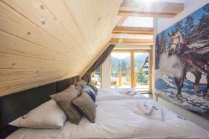 duże łóżko w pokoju z dużym oknem w obiekcie udanypobyt Apartament Sky SPA w Zakopanem