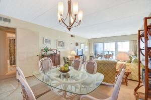 a dining room with a glass table and chairs at Oceanview Amelia South Condo in Fernandina Beach
