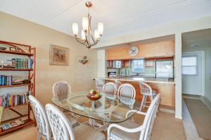 a dining room with a glass table and white chairs at Oceanview Amelia South Condo in Fernandina Beach