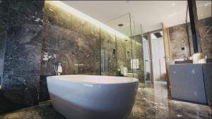 a bathroom with a large tub and a shower at Paco Hotel Guangzhou Baiyun Airport Liantang Metro in Huadu