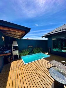 a wooden deck with a swimming pool on a house at Garden Guest House Garopaba in Garopaba