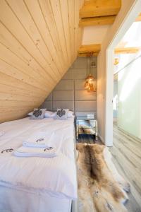 Łóżko w pokoju z drewnianym sufitem w obiekcie udanypobyt Apartament Sky SPA w Zakopanem