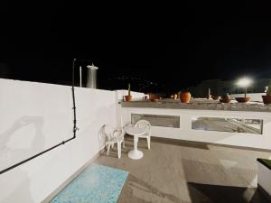 a balcony with two chairs and a table at night at La Casona de Antonio Sosa in Santa Maria de Guia de Gran Canaria