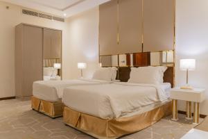 two beds in a hotel room with two lamps at Sela Hotel فندق صلة in Medina +38 photos