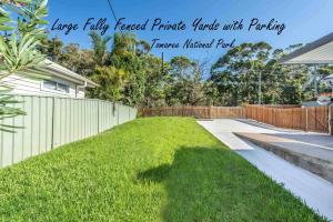 a backyard with a fence and a grass yard at Kookaburra Krib Walk 2 Little Beach and Shoal Bay in Nelson Bay