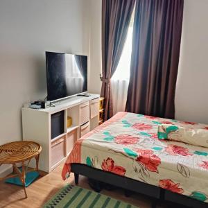 ein Schlafzimmer mit einem Bett und einem Flachbildfernseher in der Unterkunft Rania Homestay Sensory in Kajang + 6 Fotos