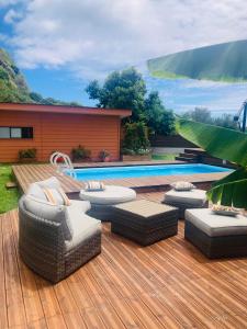 eine Holzterrasse mit Stühlen und einem Pool in der Unterkunft Noa Noa Lodge in Motu Tiahura