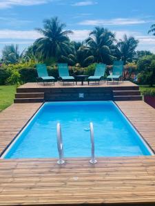 einen Pool mit blauen Stühlen und Palmen in der Unterkunft Noa Noa Lodge in Motu Tiahura