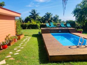 a backyard with a pool and a deck with chairs at Noa Noa Lodge in Motu Tiahura +36 photos