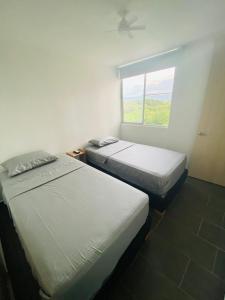 two beds in a room with a window at Apartamento Campestre con Confort y Exclusividad in Flandes