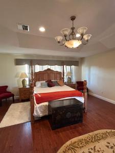 een slaapkamer met een bed en een kroonluchter bij Wellington Hideaway Villa in Wellington