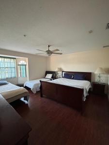 een slaapkamer met twee bedden en een plafondventilator bij Wellington Hideaway Villa in Wellington