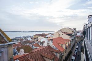 a view of roofs of buildings and the water at Breathtaking River View in Alfama in Lisbon